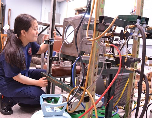 female student working on equipment in lab