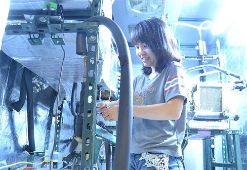 female student working on equipment in a lab